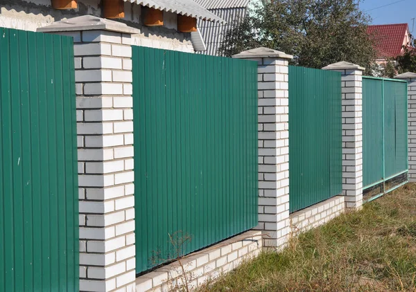 Texture of profiled metal. Metal fence. Green metallic corrugated fence