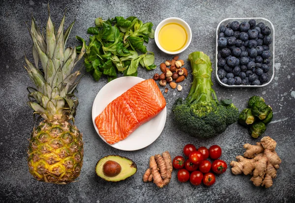 Anti inflammatory diet concept. Set of foods that help to reduce inflammation - plant based ingredients, fresh fruit, green vegetables. Healthy diet products, top view, stone background